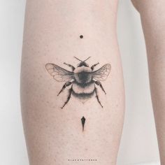 a small bee tattoo on the right side of the leg, it appears to be black and white