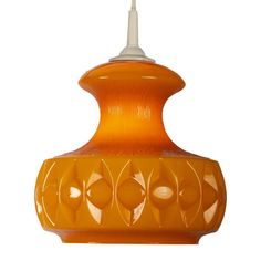 an orange glass hanging light fixture on a white background with clippings to the bottom