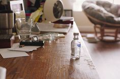 an empty bottle sitting on top of a wooden table