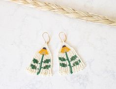 Beaded Fringe Earrings are a classic Indigenous style that is popular amongst the women in my own beading circles. I designed this pair, in shades of cream, yellow, gold, and green, to share my love of flowers. They are 3" long and 1" wide. The earrings are hand-beaded in my home in Ontario, Canada using a combination of brick stitch, square stitch and fringe. I used premium glass Toho beads and gold-plated earring lever back hooks. Cream Beaded Round Earrings, Adjustable Cream Beaded Earrings, Indigenous Style, Square Stitch, Beaded Fringe Earrings, Native American Beaded Earrings, Toho Beads, Gold And Green, Cream Yellow