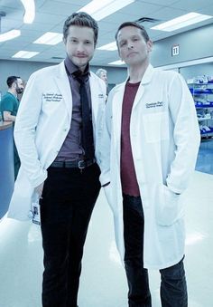 two men in lab coats standing next to each other