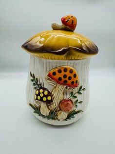 a ceramic jar with mushrooms painted on it