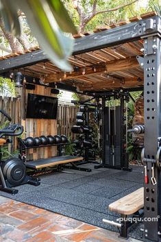 an outdoor gym area with equipment and trees in the background, surrounded by wood planks