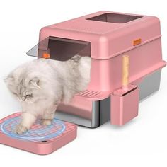 a cat that is standing in front of a small pink machine with its door open