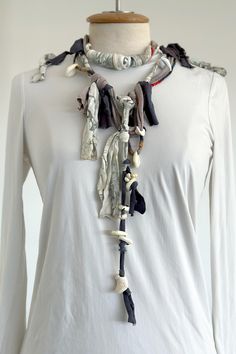 a white shirt with an assortment of scarves hanging from it's neckline