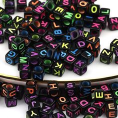 the letters are spelled with black and multicolored beads