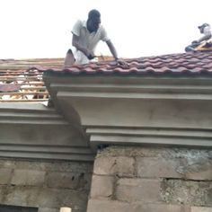 two men working on the roof of a building