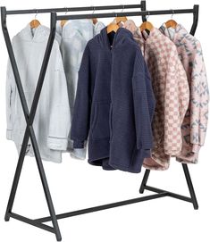 three coats hanging on a clothes rack with four sweaters and one coat hanger