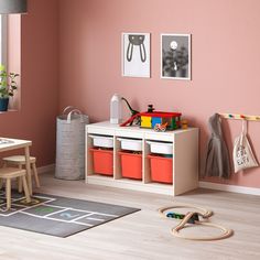 a child's room with pink walls and toys on the floor