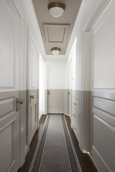 an empty hallway with white walls and wooden floors