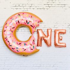 a large pink doughnut with sprinkles on it and the word nine spelled out