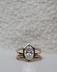 a close up of a ring with a diamond in it on a white tablecloth