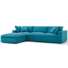 a blue sectional couch with pillows on the top and bottom part, in front of a white background