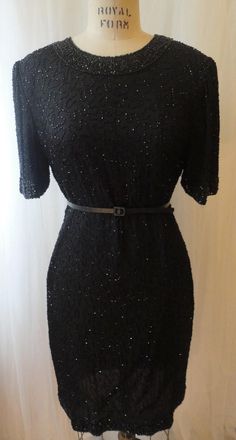 Perfectly preserved vintage SILK beaded dress. LIKE NEW!  This vintage black beaded short dress has a round high neckline, a squiggle beaded design all over with heavy beading on the collar, sleeves and hem. This simple, chic, little black dress is perfect if you are petite or like shorter hemlines.  Designer: Laurence Kazar      Size: PL (Petite Large)      Color: Black  Bust: 36 inches      Waist: 32 inches      Hips: 36 inches      Length: 36 inches      Sleeves: 11 inches Shell Fabric: 100% Beaded Dress Short, Motifs Perler, Punk Art, Beaded Collar, Goth Punk, 1980s Vintage, Beaded Dress, Collar Dress, Lining Fabric