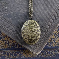 Oval vintage style locket. It is antiqued brass and the inside is quite a bit darker. On 28 inches of antiqued brass chain. Ornate Bronze Locket Necklace In Brass, Ornate Bronze Brass Locket Necklace, Vintage Brass Locket Necklace With Antique Finish, Ornate Bronze Locket Necklace With Antique Finish, Vintage Etched Oval Pendant Locket Necklace, Vintage Brass Locket Necklace In Antique Gold, Vintage Oval Pendant Necklace With Antique Finish, Ornate Antique Gold Brass Locket Necklace, Antique Silver Vintage Locket Necklace