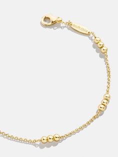 Round out your wrist stack with the Rylee 18K Gold Bracelet. Designed with an 18K gold plated sterling silver chain and accented with delicate gold beads, this accessory is equal parts modern and classic. Wear it on its own for a chic minimalist style that's sure to garner compliments. Luxury Gold Beaded Bracelets, Adjustable 14k Gold Bracelet With Gold Beads, Adjustable Gold Chain Bracelet For Everyday Luxury, Gold Adjustable Bracelet With Polished Finish, Classic Adjustable Gold-tone Gold Bracelet, Classic Gold-tone Jewelry With Bracelet Strap, Adjustable Yellow Gold-plated Pearl Bracelet, Timeless Adjustable Gold Bracelet With Solid Link, Gold-plated Gold Bracelet For Everyday Luxury