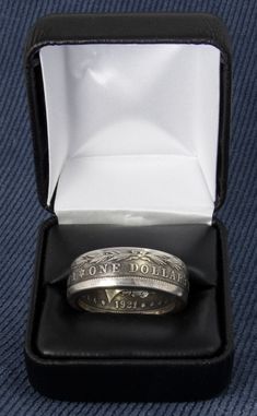 "This Double Sided Silver Coin Ring was handmade from a 90% Silver US Morgan Dollar Coin, minted in 1921. It's available in sizes 10-22, including half sizes. This 3D coin ring reads \"ONE DOLLAR\", \"UNITED STATES OF AMERICA\" & \"IN GOD WE TRUST\" on the outside & \"E PLURIBUS UNUM\" with mint date on the inside. The band width is approximately 9 mm wide. General information: All of our silver coin rings have rounded edges for comfort and come in a black ring box suitable for gifting. Black Ring Box, Silver Coin Ring, 100 Birthday Gifts, Coin Rings, Custom Coins, Morgan Dollars, Leather Ring, Silver Anniversary, 100th Birthday