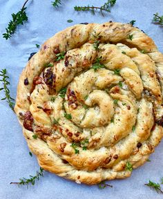 a close up of a pastry on a table with green sprigs around it