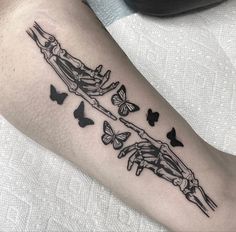 a woman's arm with butterflies on it and a skeleton in the middle of her arm