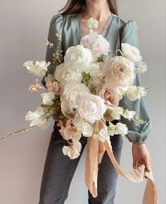 a woman holding a bouquet of flowers in her hands