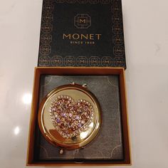 a gold heart shaped pocket watch in a box