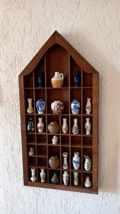 a wooden shelf with many different vases on it