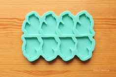 four ice trays shaped like teeth on a wooden surface