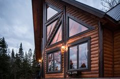 a log cabin with large windows at dusk