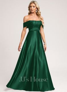 a woman in a long green dress posing for the camera with her hands on her hips