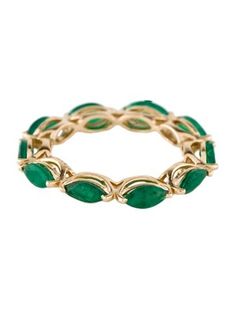 a gold ring with green stones and leaves on the inside, set against a white background