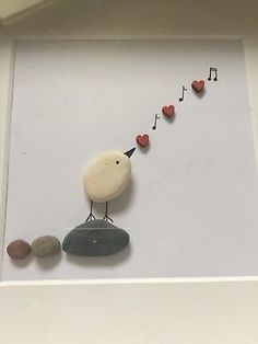 a white bird sitting on top of a rock with musical notes coming out of it