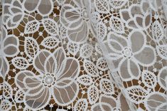 an image of white lace with flowers on it