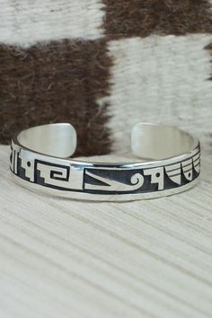 This sterling silver bracelet was made by Hopi silversmith Timothy Mowa. The inside is signed and stamped sterling.Size: 5 5/8" (will fit up to a 6 3/8" wrist)Gap: 3/4"Width: 1/2"Free shipping on all orders! We ship with USPS and always include tracking. All orders ship within a day of payment.Returns are accepted up to 30 days after you receive your order. Just send us a message. Our shop offers cash back or store credit. The item must be returned in new condition. Southwestern Style Etched Sterling Silver Bracelet, Southwestern Silver Stamped Cuff Bracelet, Sterling Silver Bracelets Bangles Native American, Southwestern Sterling Silver Bracelet With Turquoise Inlay, Nickel-free Southwestern Sterling Silver Bracelet, Native American Jewelry, Bracelets And Charms, Free Jewelry, Sterling Silver Bracelets