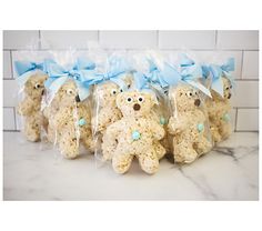 teddy bears are wrapped in plastic bags with blue bows on their heads and ears, as if they were made from rice krispy treats