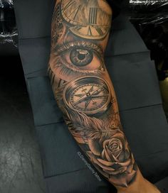 a person with a tattoo on their arm that has an eye, clock and rose