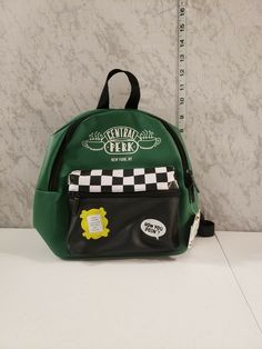 F.R.I.E.N.D.S. Central Perk Mini Backpack Purse Handbag. Condition is "New with tags". Shipped with USPS Priority Mail. THANKS FOR CHECKING OUT OLIVER'S EMPORIUM HOUSE OF VINTAGE TREASURES COLLECTIBLES & MORE HAVE A LOOK AROUND SOMETHING IS BOUND TO FIND YOU WE ARE SEEKERS OF ANYTHING AWESOME..NEW ITEMS ADDED WEEKLY  IF YOU HAVE QUESTIONS MESSAGE ME ANYTIME I'LL DO MY BEST TO GET YOU AN ANSWER WE SELL USED OR PRE-OWNED ITEMS TO CLOTHES AND TOYS VINTAGE COLLECTIBLES AND MUCH MORE ALL OF OUR PRE-O Casual Softback Backpack For Errands, Retro Bags With Zipper Closure For Back To School, Trendy Green Standard Backpack, Green Standard Backpack For Errands, Retro Green Standard Backpack, Casual Backpack For Errands, Casual Standard Backpack For Errands, Casual Standard Backpack, Green Backpack With Adjustable Strap For Errands