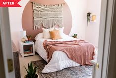 a bed room with a neatly made bed next to a window and a potted plant