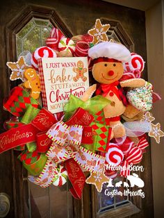 a christmas wreath with a teddy bear and candy canes hanging on the front door