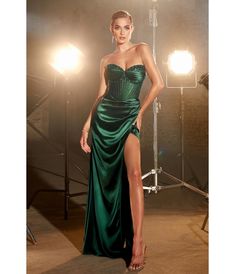 This ravishing evening gown exudes unparalleled luxury, boasting a striking emerald hue that effortlessly captivates all eyes. Its strapless illusion sweetheart neckline adds an element of romantic allure, while intricate daisy beaded motifs delicately adorn the bodice, shimmering with each graceful movement you make. Crafted from sumptuous satin, this dress features pleated cups that beautifully enhance your natural curves and a sheer corset boned bodice for added support and sophistication. The drama continues as you turn heads with the open lace-up back elegantly cascading down to reveal a zipper closure. A floor-length fitted skirt hugs your silhouette flawlessly, adorned with a side leg slit that creates an enticing glimpse of skin. Completing this picture-perfect ensemble is its swee Satin Corset Prom Dress, Beaded Motifs, Corset Prom Dress, Sheer Corset, Graceful Movement, Corset Boning, Cinderella Divine, Boned Bodice, Corset Dress Prom