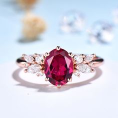 a close up view of a ring with a pink stone surrounded by white and clear stones