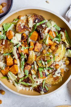 a bowl filled with vegetables and dressing on top of a white tablecloth next to other dishes