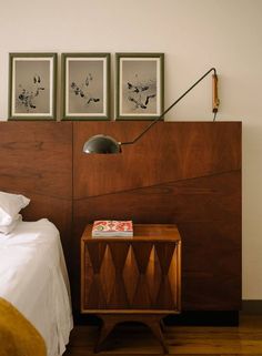 a bed room with a neatly made bed and two pictures on the wall above it