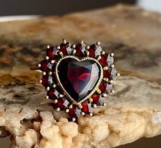 An old stock antique Victorian bohemian garnet ring set in 14k gold. In immaculate condition.  A dear heart ring set in garnet symbolizes passion and love. They are usually given to their sweetheart. Natural rose cut garnets. 14K solid gold. Size 6 and easily sizable by your local jeweler.   Open back Garnet Heart Ring, Vintage Ruby Ring For Valentine's Day Anniversary, Vintage Gemstone Rings For Valentine's Day, Vintage Ruby Ring For Anniversary On Valentine's Day, Vintage Heart Ring With Birthstone For Valentine's Day, Vintage Heart Ring With Birthstone, Victorian Wedding Ring, Garnet Ring Vintage, Victorian Romance