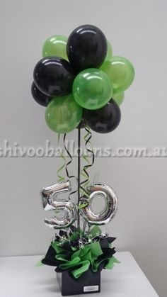 a black and green balloon with the number 50 on it is sitting in a vase