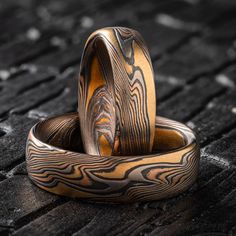 "* Price may vary depending on ring size, please inquire with us directly with your needed size for accurate pricing! These hand-crafted Mokume Gane bands are shown in the Twist pattern and the  Firestorm metal combination, with a low dome profile and etched + oxidized finish. The Firestorm palette features 14k red gold, 14k yellow gold, Palladium, and sterling silver.  Ring 1 Pattern: Twist Palette: Firestorm Width Shown: 6mm Size Shown: 9 Profile: Low Dome Finish: Etched + Oxidized  Ring 2 Pattern: Twist Palette: Firestorm Width Shown: 5mm Size Shown: 5.25 Profile: Low Dome Finish: Etched + Oxidized  Price does NOT include stones or setting fees. All Arn Krebs Mokume Gane Rings are CUSTOM and made-to-order. Rings are available in any size, width, profile, pattern, metal combination and f Luxury Carved Jewelry For Weddings, Unique Engraved Ring For Wedding, Unique Engraved Wedding Ring With Etched Design, Unique Engraved Etched Wedding Ring, Unique Carved Rings For Wedding, Artisan Engraved Ring For Wedding, Artisan Hand Forged Jewelry For Weddings, Unique Etched Jewelry For Wedding, Carved Adjustable Jewelry For Wedding