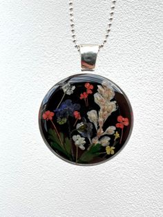 Wild flowers meadow silver plated pendant - epoxy resin necklace with real dried flowers on silver plated or sterling silver chain. Can be personalised with silver plated letter. Message me for your letter option. Flowers always attract us towards their beauty and nature. They impart a feeling of freshness and soften our hearts when we are sad and fatigued. They purify our surroundings and uplift our life when we are feeling blue. *Please note this piece contains natural inclusions which may con Nature-inspired Silver Jewelry With Pressed Flowers, Silver Nature-inspired Jewelry With Pressed Flowers, Silver Flower-shaped Resin Necklace, Silver Resin Necklaces With Pressed Flowers, Handmade Sterling Silver Botanical Necklace, Handmade Sterling Silver Flower Necklace With Round Pendant, Silver Resin Flower Jewelry, Nature-inspired Silver Resin Jewelry, Silver Flower Shaped Resin Jewelry