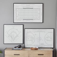 two framed sports drawings hang on the wall next to a dresser in a living room