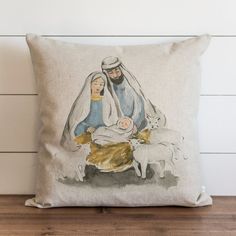 a pillow with a nativity scene on it and a sheep in the foreground