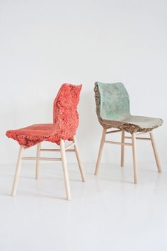 two chairs made out of wood and fabric on white background, one is red and the other is green