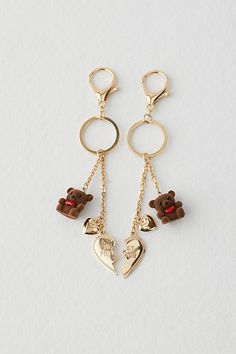 two key chains with teddy bears and hearts attached to them, hanging from the ends